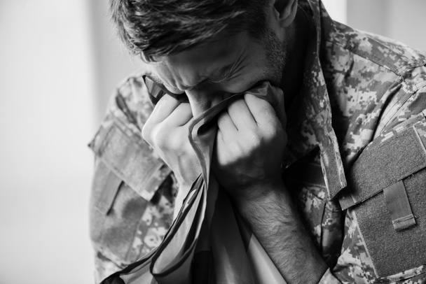 stock-photo-military-man-uniform-crying-while-holding-american-flag-monochrome
