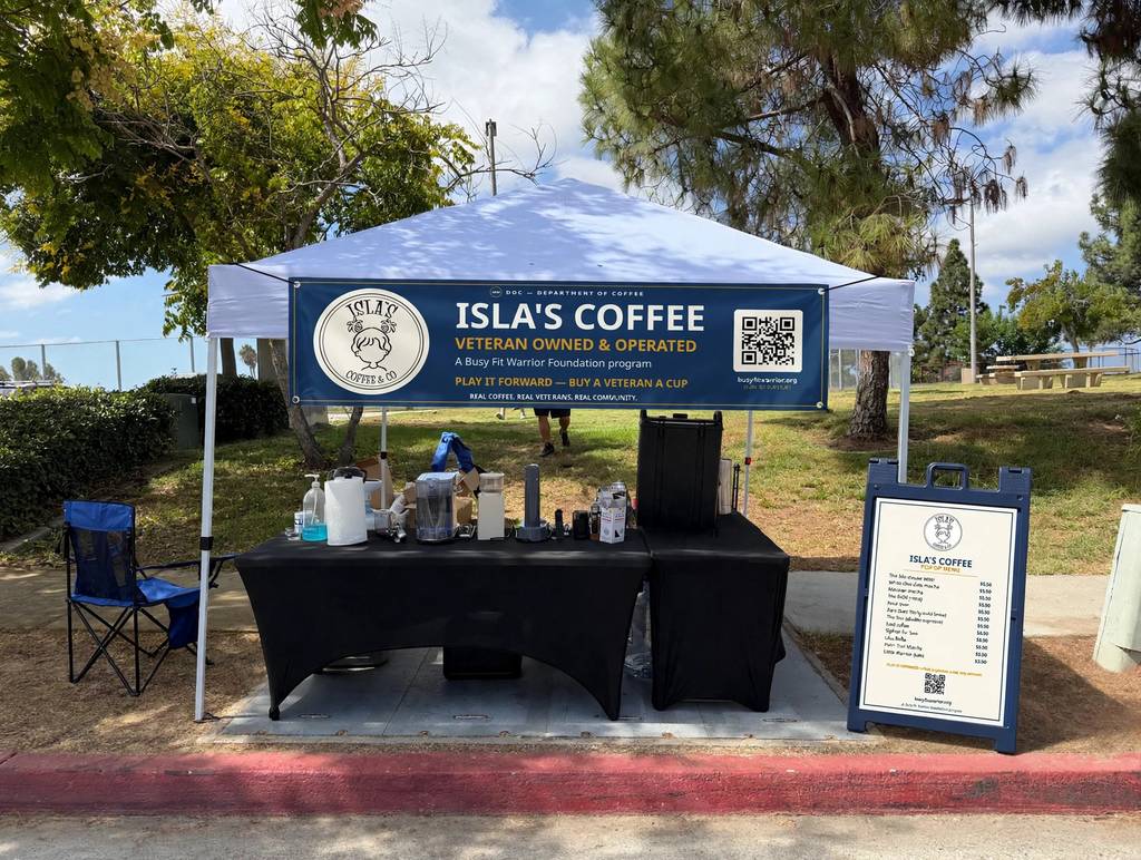 Isla's Coffee pop-up setup with branded banner and menu sign